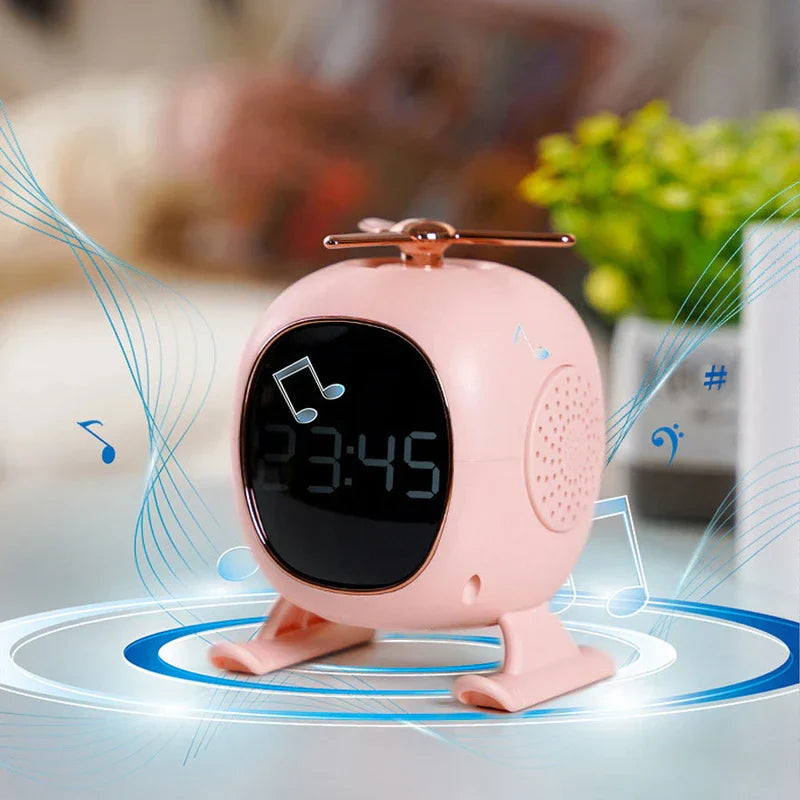 Pink helicopter-shaped bluetooth speaker displays 23:45 with music note graphics around it.