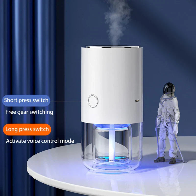 humidificador blanco con luces LED azules que libera niebla, junto a una figura de astronauta; las etiquetas de texto muestran pulsación corta para cambiar de marcha, pulsación larga para control por voz