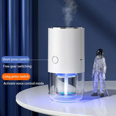 humidificador blanco con luces LED azules que libera niebla, junto a una figura de astronauta; las etiquetas de texto muestran pulsación corta para cambiar de marcha, pulsación larga para control por voz