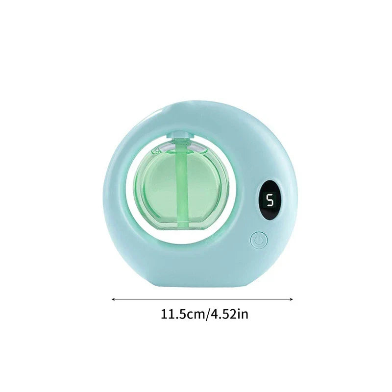 Light blue aerosol air freshener dispenser with green reservoir, digital display showing 5, width labeled 11.5cm/4.52in