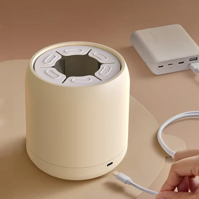 Milk Shaker - Hand holds a USB-C cable near the device's charging port, with a power bank and coiled cable nearby.