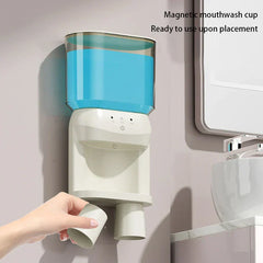 Wall-mounted mouthwash dispenser with magnetic cups, a hand removing one cup in a bathroom