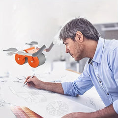 Ab Roller Wheel - Gray-haired man in light blue shirt draws on paper with a pencil; an orange and gray dual-wheel device hovers nearby.