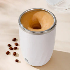 Automatic Mixing Mug Cup - White insulated mug actively stirring light brown coffee with coffee beans beside it
