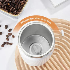 Automatic Mixing Mug Cup - Top-down view of a white cup with 304 stainless steel interior, placed on a wooden mat with coffee beans nearby