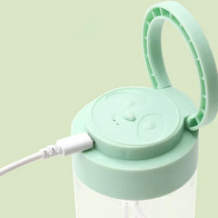 Automatic Mixing Mug - Close-up of a mint green electric blender cup lid with a USB charging cable plugged in, flip-up carry ring open, and panda face embossed on top