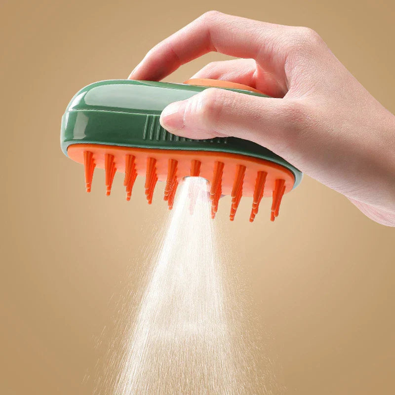 Hand holding a green and orange pet grooming brush that sprays a fine mist from its center