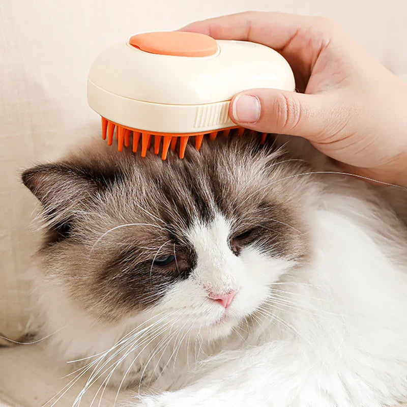 Pet Grooming Brush - A hand holds a cream and orange pet brush against the head of a relaxed longhair cat with white and brown fur.