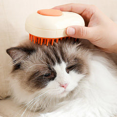 Pet Grooming Brush - A hand holds a cream and orange pet brush against the head of a relaxed longhair cat with white and brown fur.