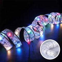 Battery Box - Coiled translucent printed ribbon with multicolor LED lights glowing against black background, small product inset at bottom right