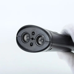 Dog Training Clicker - Close-up of the end of a black handheld device with two mesh-covered circular openings, held by a white-gloved hand against a plain light background