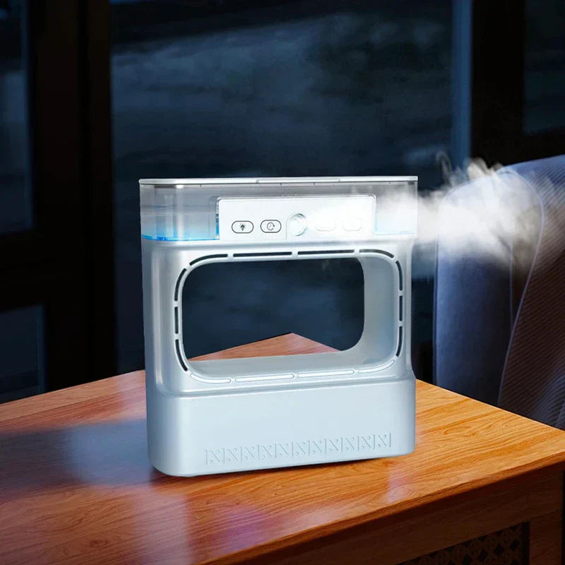 A silver air cooler humidifier on a wooden table, emitting mist from its right side.