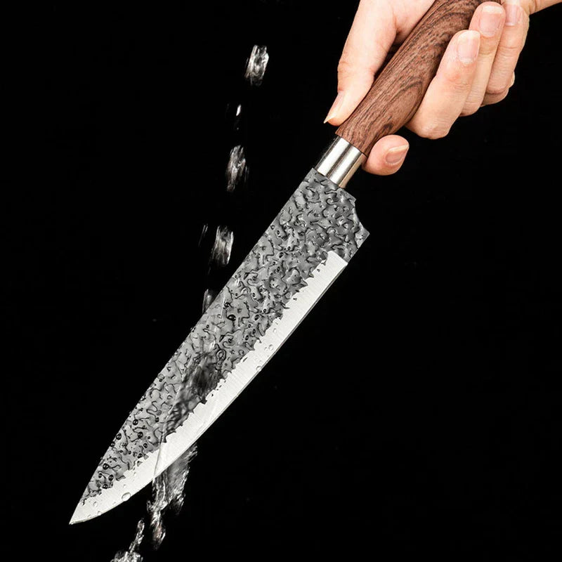 Hammered Knife Set - A hand holds a textured blade kitchen knife, with water splashing across the blade against a black background.