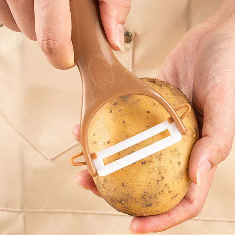 Hammered Knife Set - Hands hold a brown-handled peeler against a whole potato, with an apron in the background.