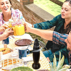 Fly Repellent Fan Device - Black spinning blade device sits on a checkered outdoor picnic table with people clinking juice glasses, pastries, and tableware nearby