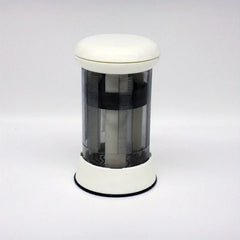 Butter Grater - white and clear cylindrical mill dispenser standing on plain light gray background