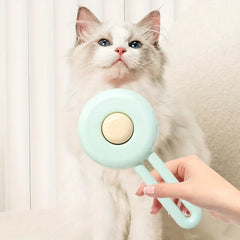 Cat Grooming Brush - Mint green pet brush held in hand in front of a long-haired blue-eyed cat