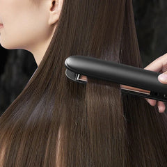 Plancha de pelo de cerámica: una persona usando una plancha de pelo negra sobre cabello liso y castaño largo