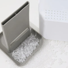 Chopstick Utensil Drainer Caddy Basket - Gray plastic holder with clear round beads, scattered matching beads, and a white perforated plastic container on a white surface