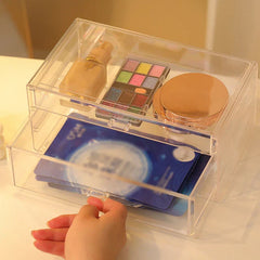 Plastic Storage Container - Clear plastic drawer organizer holding makeup products, with a hand pulling the lower drawer open