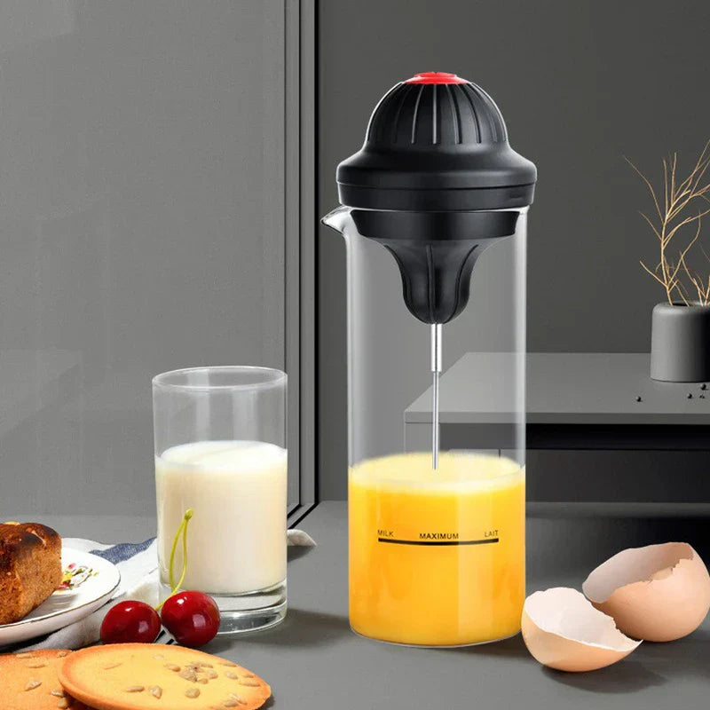 Coffee Drink Stirrer Electric Foaming Tool - Electric beverage foamer with yellow liquid inside, styled with milk glass, pastries, and cherries on countertop