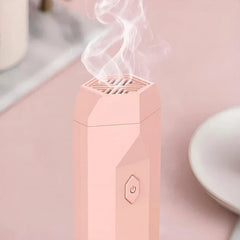 Aroma Diffuser Hair Brush - pink unit close-up with mist releasing from top vent, tabletop setting