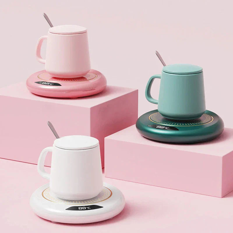calentador de taza - Calentador de taza de temperatura constante con base calefactora, tres calentadores en rosa, verde y blanco, cada uno sosteniendo una taza con tapa a juego sobre bloques de exhibición rosas