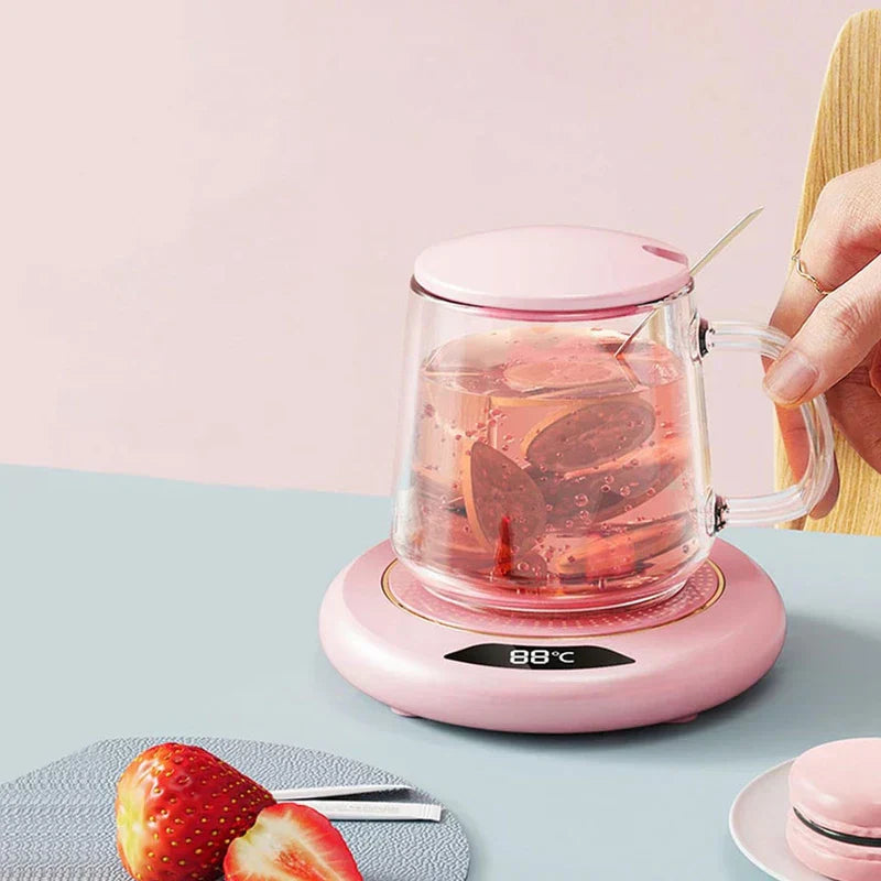 calentador de taza - Calentador de taza rosa con vaso de vidrio de té de frutas, mano sosteniendo el asa de la taza, fresa y macarrón sobre mesa azul claro