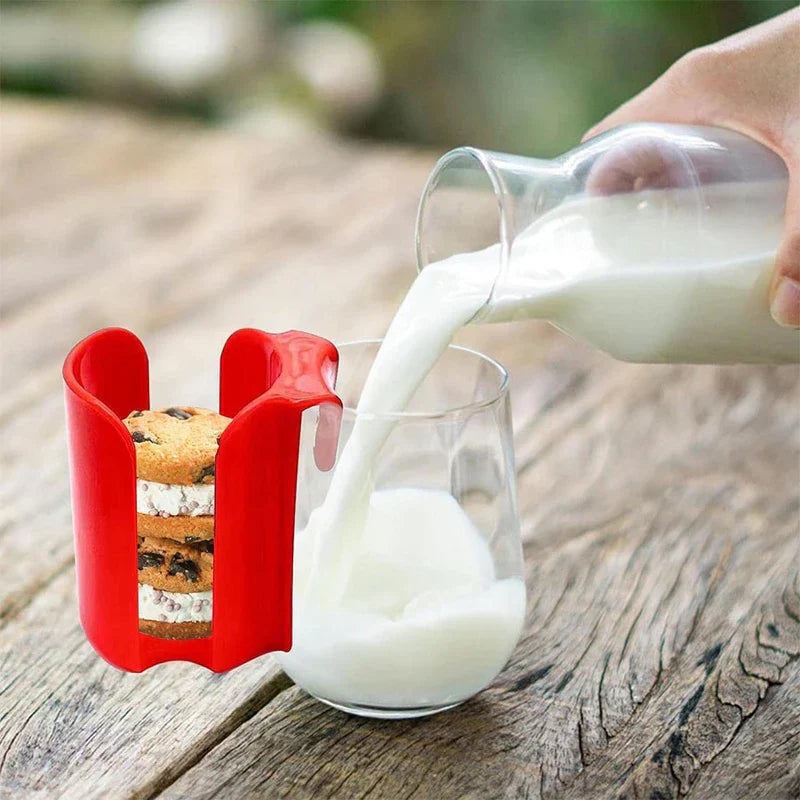 soporte expositor para galletas y bizcochos con rejilla - Soporte de plástico rojo para golosinas junto a un vaso que se llena de leche sobre una mesa de madera