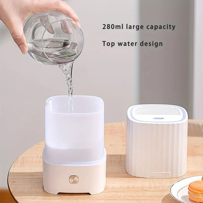 Bedroom Humidifier - Hand pours water from glass into the top of a white humidifier; second humidifier and plate with macaron sit on wooden table, with text noting 280ml capacity and top water design