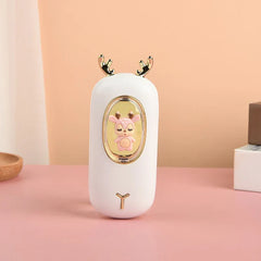 Rechargeable Hand Warmer - White deer design unit with gold antlers and embedded pink deer figurine, displayed on a pink surface