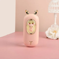 Rechargeable Hand Warmer - Pink deer-themed handheld device with golden antlers, a pink deer figurine behind a clear oval window, and a small golden Y-shaped detail below