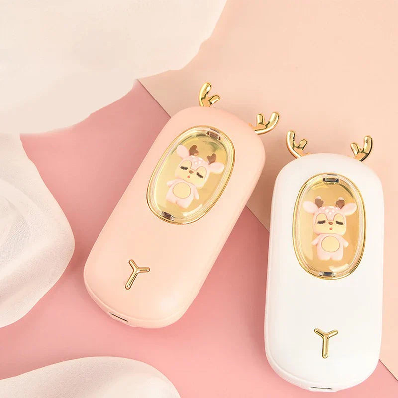 Rechargeable Hand Warmer - Side-by-side view of light pink and white deer design units, showing charging ports at the base