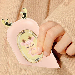 Rechargeable Hand Warmer - Close-up of a hand holding a pastel pink deer-themed device with golden antlers and a small pink deer figurine inside an oval window
