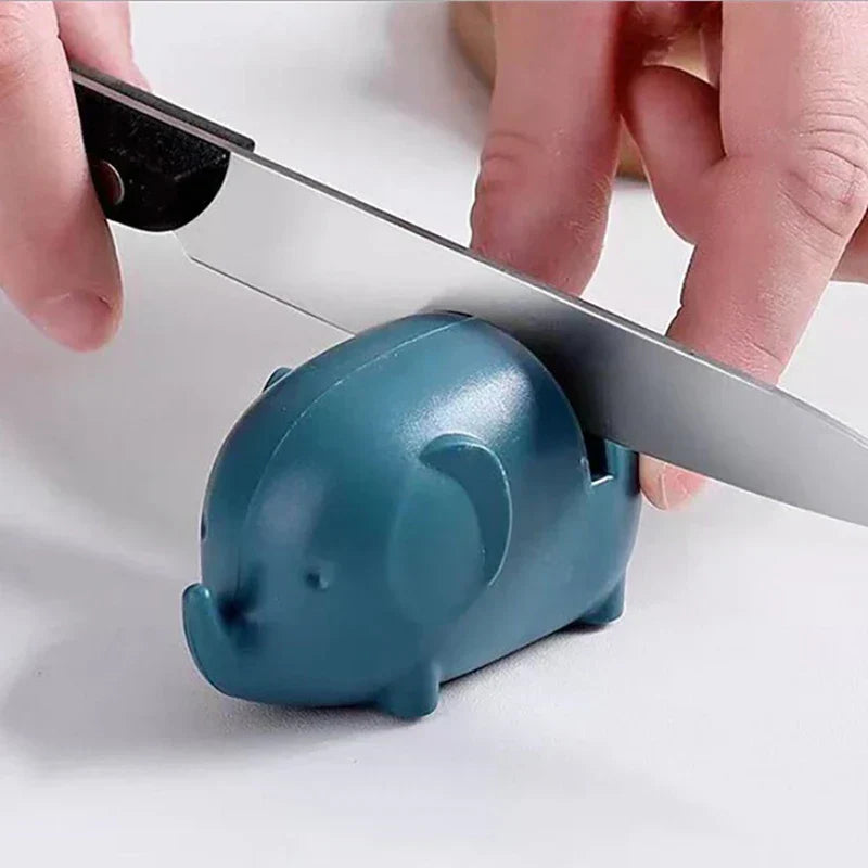 Mini Knife Sharpener - Two hands pulling a kitchen knife through the teal colored sharpener on a white countertop