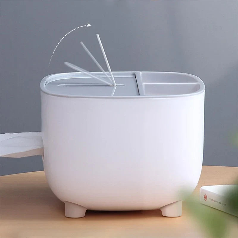 A desktop organizer shelf with tissue box holder demonstrates cotton swabs lifting from its top slot, with tissue extending from its side opening.