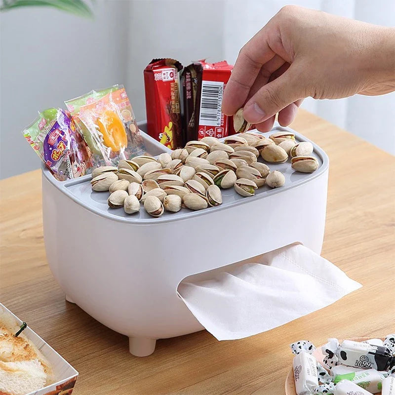 A desktop organizer shelf with tissue box holder sits on a wooden table, holding candies and pistachios, with a hand picking up a pistachio.