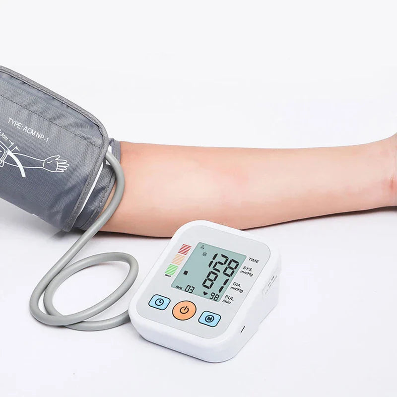 Automatic upper arm blood pressure monitor on an arm with cuff, showing readings on its digital display