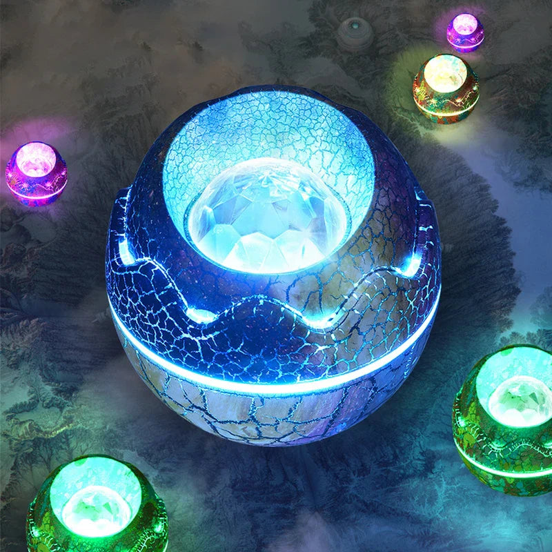 Star Projector Light - Top-down view of glowing blue cracked egg projector with faceted projection lens, surrounded by smaller multicolor glowing units