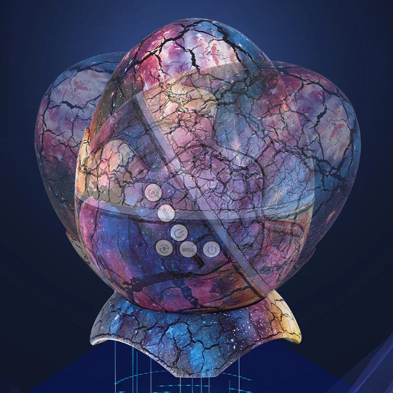 Star Projector Light - Galaxy-colored cracked egg-shaped device displayed from a slightly elevated front angle, against a dark blue background, showing its printed exterior.