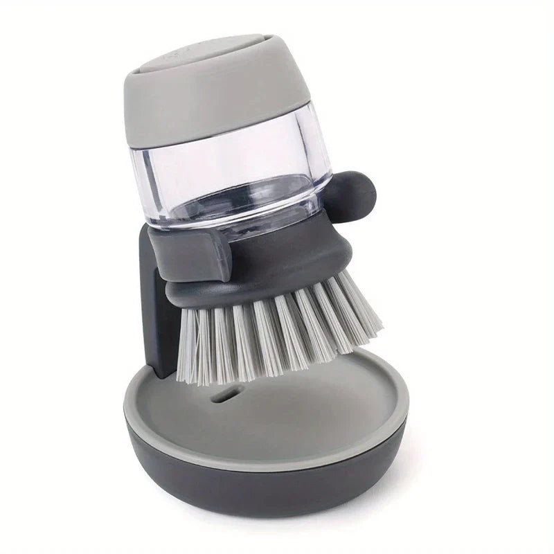Soap dispensing palm dish brush resting on its matching gray stand against a white background