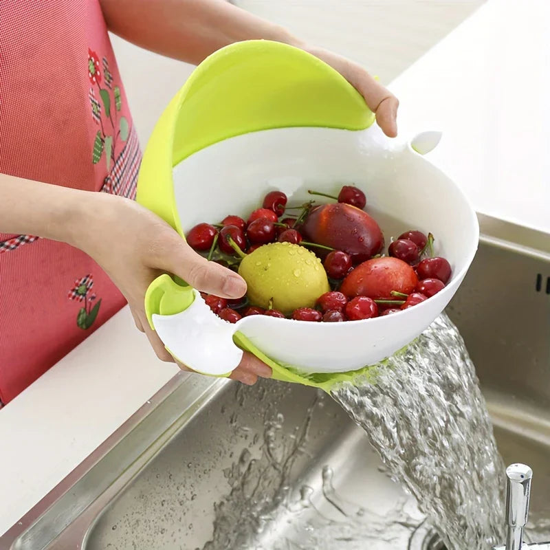 Colander Bowl Set - Person holding the unit over a sink, draining water from washed fruit inside