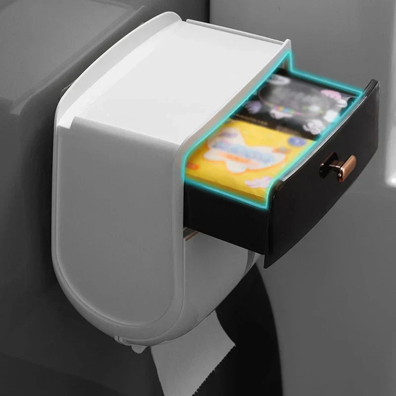 Portapañuelos: dispensador de papel higiénico con cajón superior abierto mostrando artículos guardados y papel higiénico colgando de la parte inferior