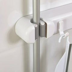 Double Mop Broom Holder - Close-up of a roller grip slot securing a metal tool handle, with an adjacent small hook