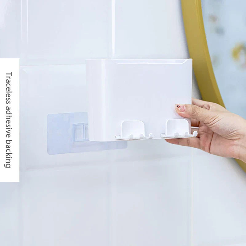 Cup Holder Set - Hand positioning the organizer onto a clear adhesive wall mount, showing built-in hanging hooks on the unit base