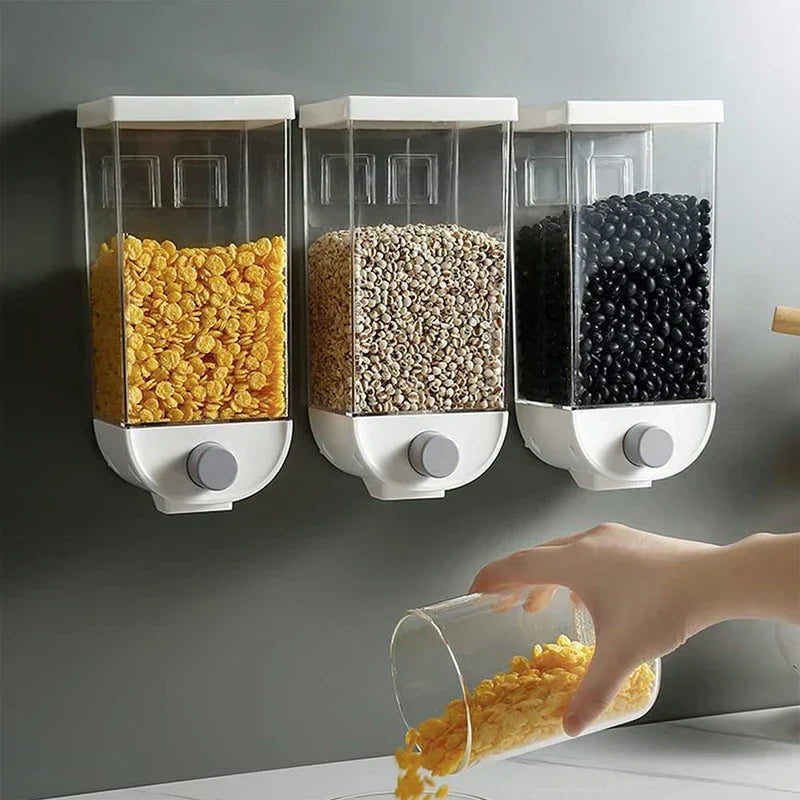 Dry Food Container - Three wall-mounted storage dispensers holding cornflakes, grains, and black beans, with a hand dispensing cornflakes into a glass cup