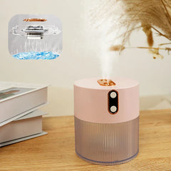 Humidifier Diffuser - Pink dual-nozzle humidifier emitting mist on a wood table beside stacked books, with an inset diagram showing water circulation