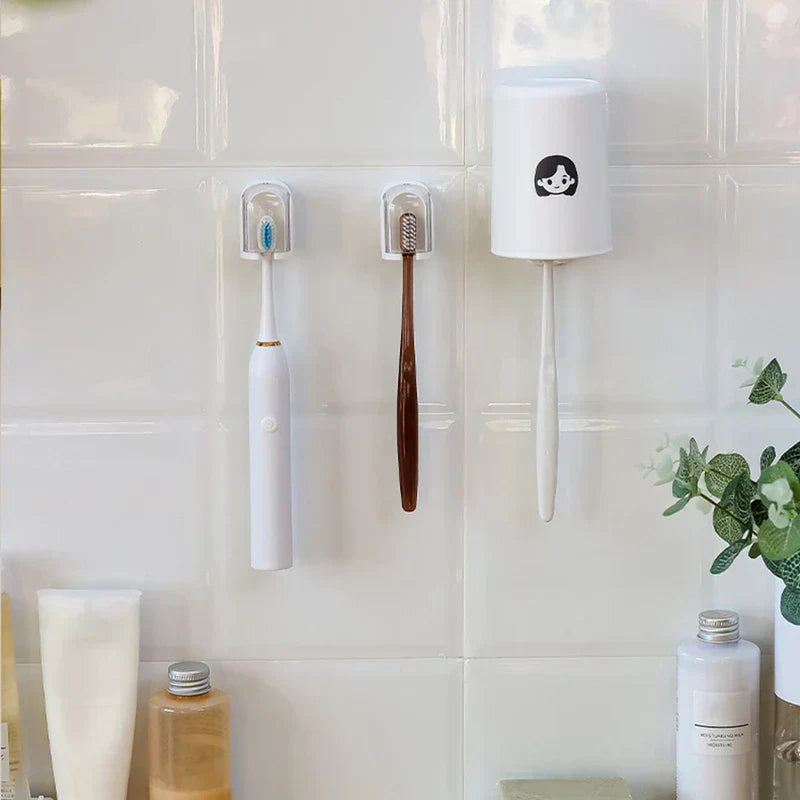Toothbrush Holder - Three holders mounted on a white tiled bathroom wall holding manual and electric toothbrushes