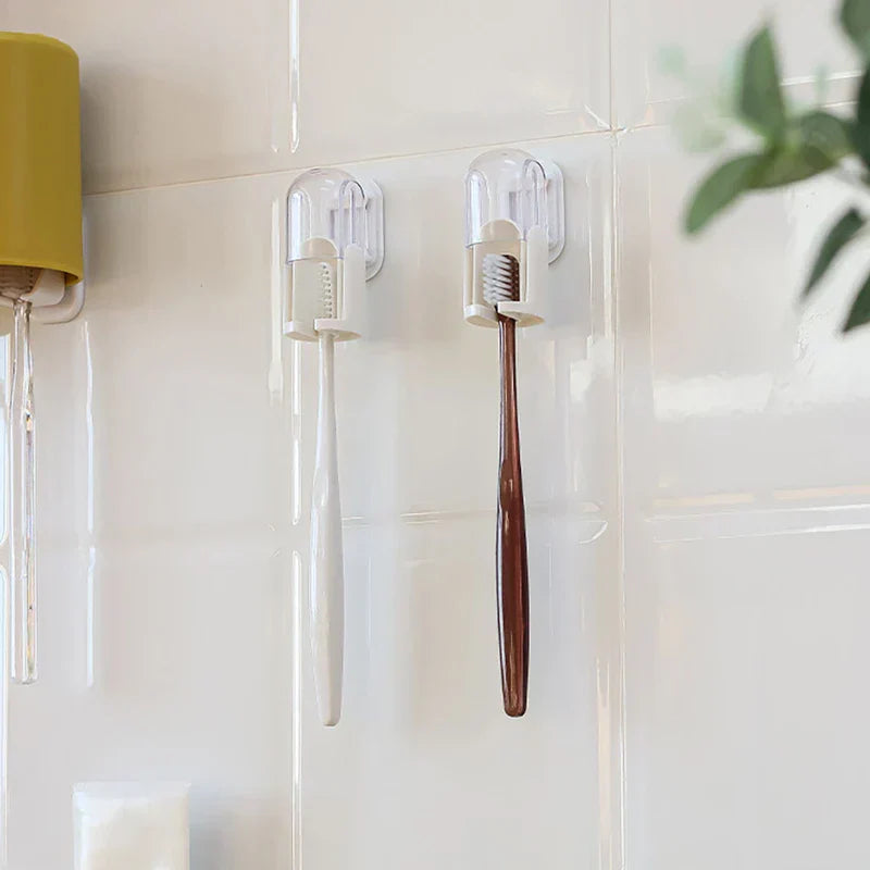Toothbrush Holder - Two wall-mounted toothbrush holders holding a white-handled toothbrush and a brown-handled toothbrush, mounted on a white tiled bathroom wall.