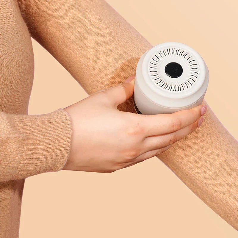Lint Remover - A hand holds a white fabric shaver against a person's leg covered in tan fabric